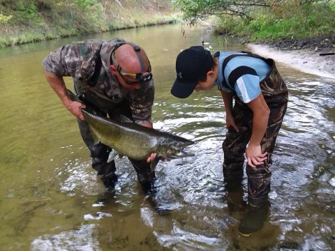 Father showing a son his caught fish